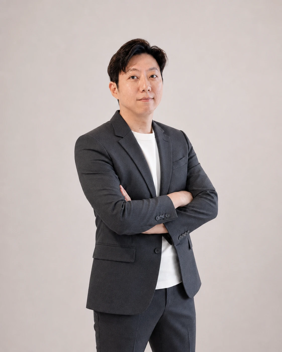 尤金資本創辦人暨總經理王佑哲，身穿深灰色西裝雙手交叉站立